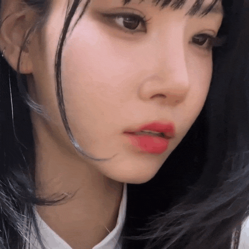 a close up of a woman 's face with red lipstick on her lips