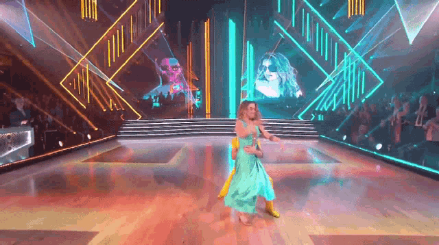 a couple of women are dancing on a dance floor in front of a crowd