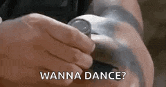 a person is holding a watch in their hand and says `` wanna dance '' .