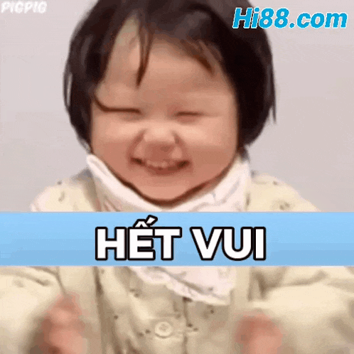 a baby girl is smiling with her eyes closed and a blue background with the words het vui written on it .