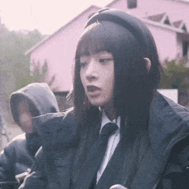 a girl wearing a headband and a black jacket