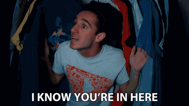 a man standing in front of a closet with the words " i know you 're in here " above him