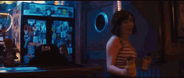 a woman in a striped shirt is standing in front of a door that says l.a. on it