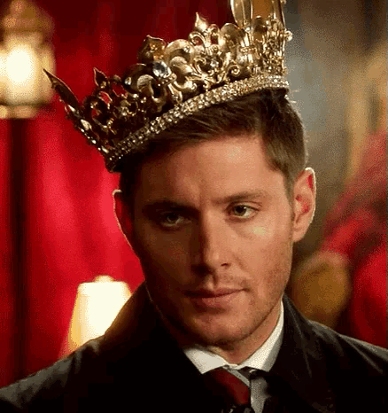 a man in a suit and tie is wearing a crown .