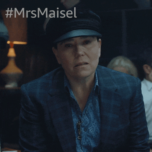 a woman wearing a hat and a suit says " yes "
