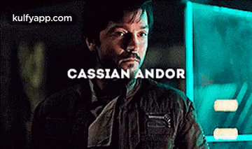 a man with a beard and mustache is standing in front of a sign that says cassian andor .