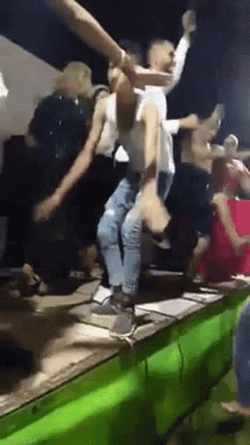 a group of people are dancing on a stage at a party