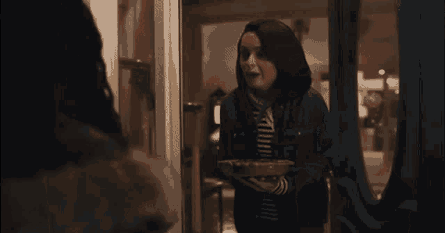 a woman is holding a plate of food in her hand .