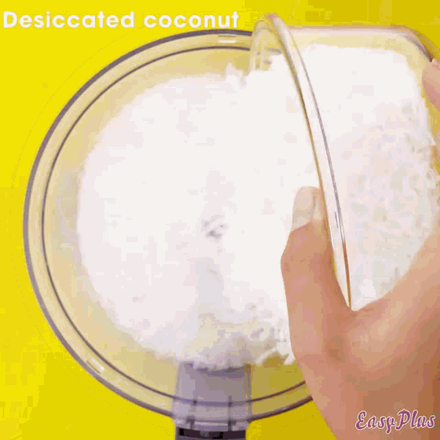 desiccated coconut is being poured into a food processor