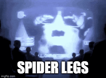 a group of people sitting in front of a screen that says spider legs .