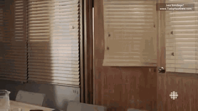 a room with blinds and a sign that says " into bondage " on it