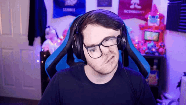 a man wearing headphones and glasses is making a funny face .
