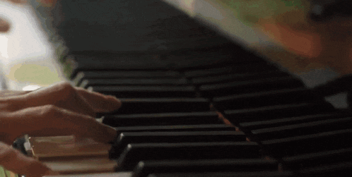 a person is playing a piano with their hands on the keys .