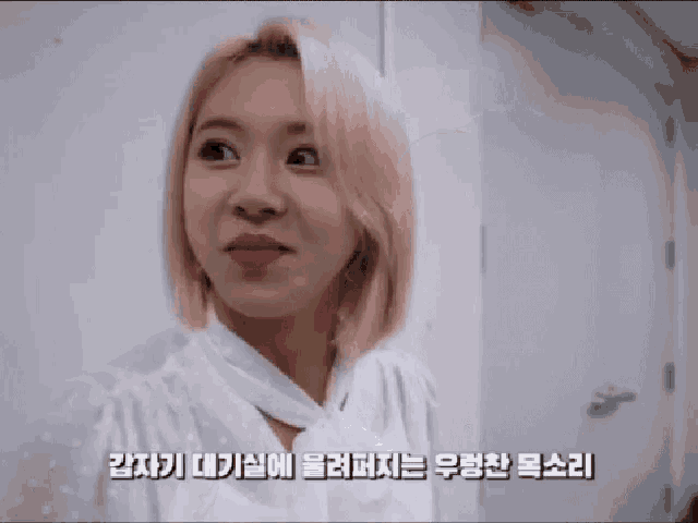 a woman with blonde hair is making a funny face in a room with korean writing on the bottom