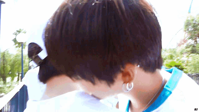 a close up of a person 's head with a white hat and earrings
