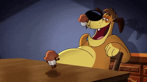 a cartoon dog is sitting at a table with two cupcakes in its mouth