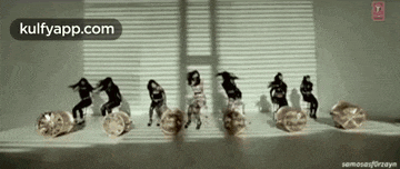 a group of people are dancing in a room with a clock in the middle .