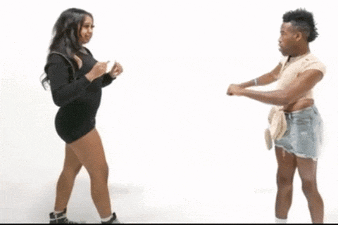 a man and a woman are dancing in front of a white wall .