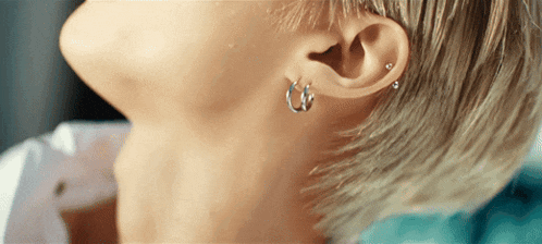 a close up of a person 's ear with earrings and piercings