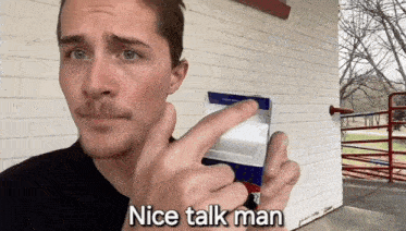 a man is holding a carton of milk and pointing at it with the words nice talk man below him