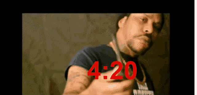 a man is holding a pair of scissors and 4:20 is written in red