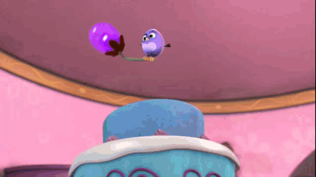a cartoon bird is holding a purple balloon above a blue cake