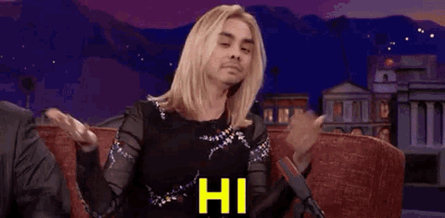 a man with blonde hair is sitting on a couch with his arms outstretched and the words `` that 's me '' .
