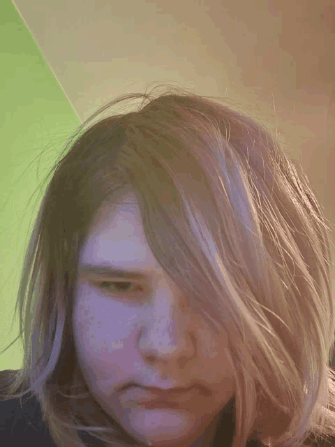 a close up of a woman 's face with a green background