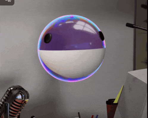 a purple and white ball floating in the air next to a microphone