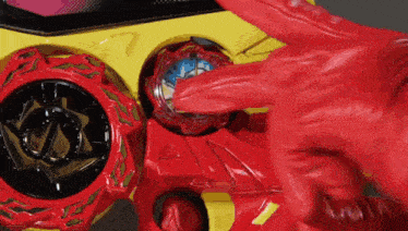 a person wearing a red glove is holding a red toy .