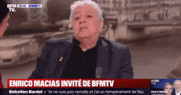 enrico macias is being interviewed by a woman on bfm tv