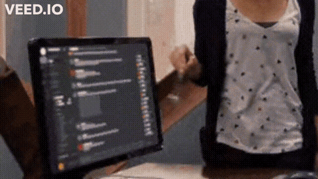 a woman is standing in front of a computer screen that says " veed.io " on the bottom