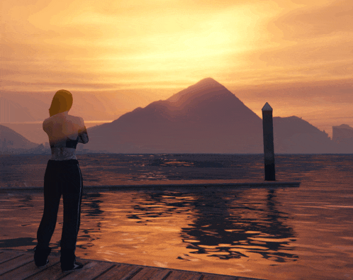 a woman is standing on a dock looking at the sunset