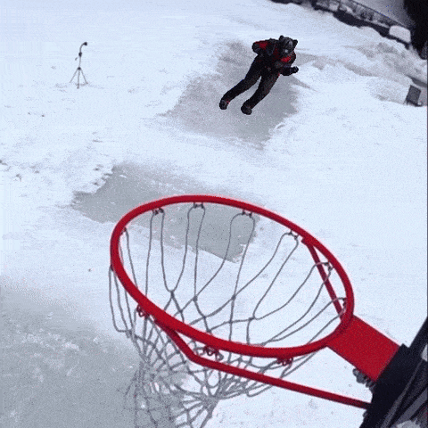a person in a batman costume is jumping over a basketball hoop