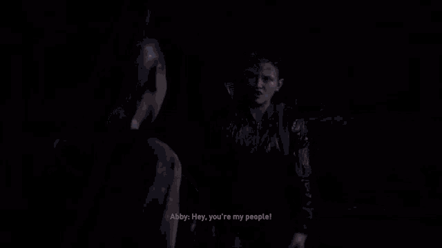 a woman is talking to a man in a dark room and says `` hey , you 're my people '' .