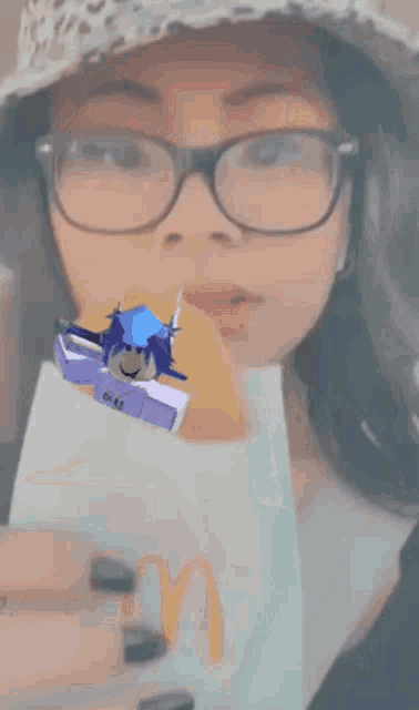 a woman wearing glasses is eating a mcdonald 's hamburger