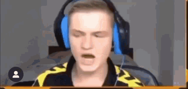 a man wearing headphones is sitting in a chair with his eyes closed and his mouth open .