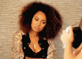 a woman with curly hair is being photographed by someone