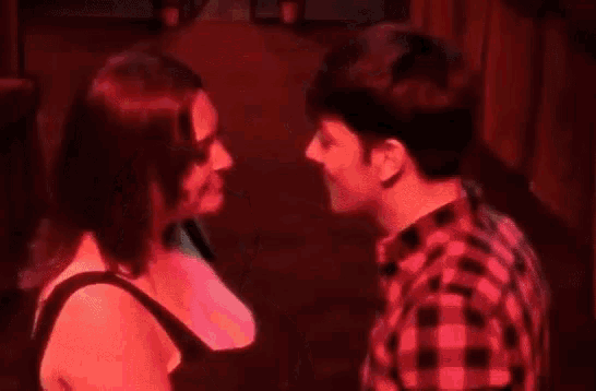 a man and woman are kissing in a hallway .