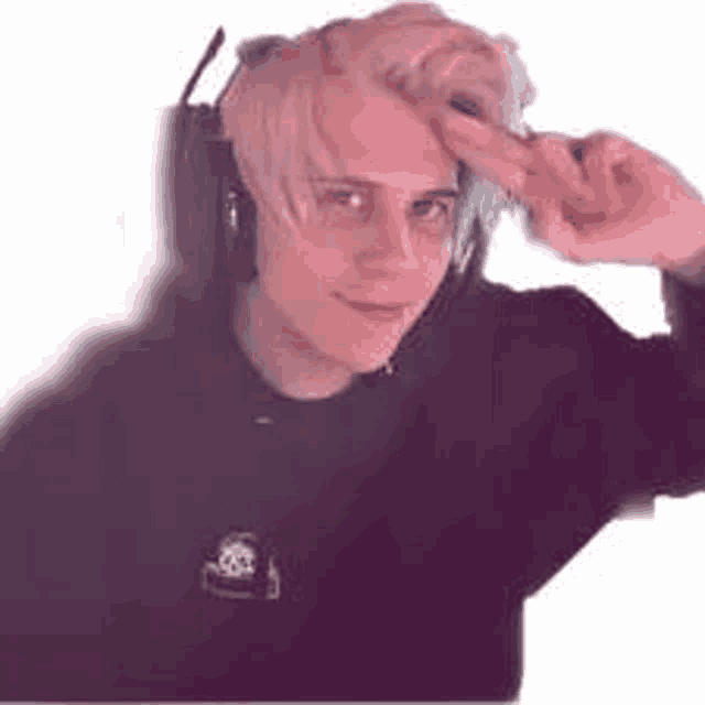 a young man wearing headphones and a black shirt is making a funny face .