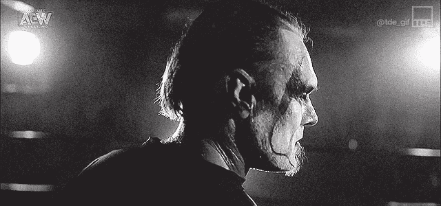 a black and white photo of a man with a beard and a ponytail .