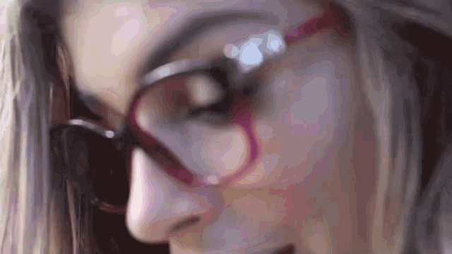 a close up of a woman 's face wearing glasses .
