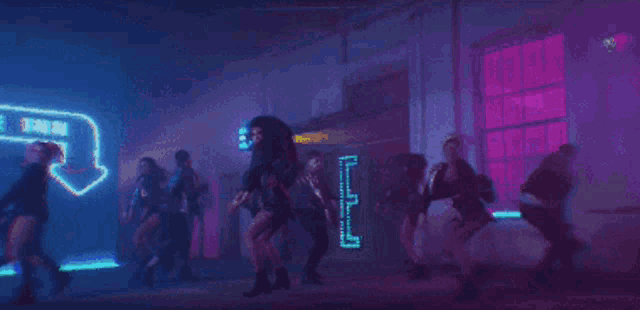 a group of people are dancing in a dark room with neon lights