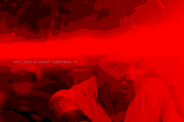 a red light is shining on a man 's face with the words but you cannot control it below him