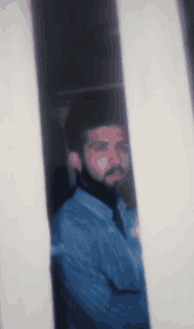 a man with a beard is behind a fence