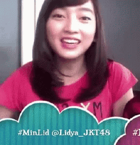 a woman in a pink shirt is smiling in front of a speech bubble that says # minlid @ lidya_jkt48