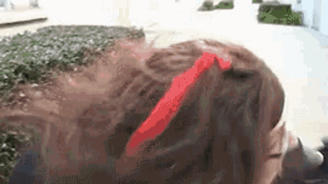 a close up of a person 's head with a red ribbon on it .