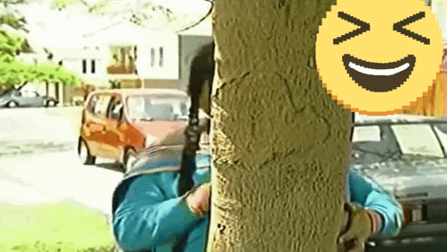 a pixelated smiley face is behind a person standing next to a tree