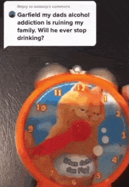 a person is holding a clock with garfield on it and a reply to kedocp 's comment .