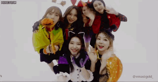 a group of young women dressed in halloween costumes are posing for a photo .